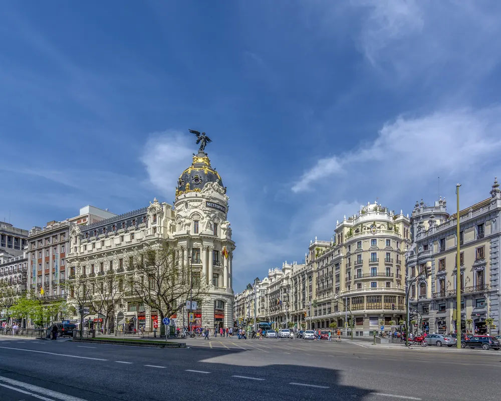 Edificio Metrópolis y la Gran Vía de Madrid en un día soleado de primavera